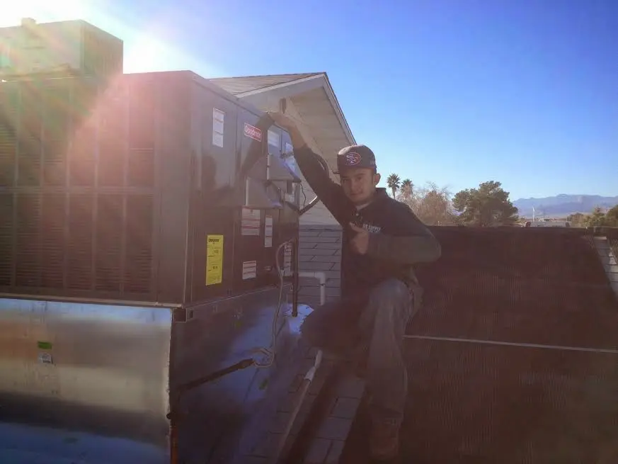 HVAC technician performing Air Duct Cleaning on a rooftop unit in Severance
